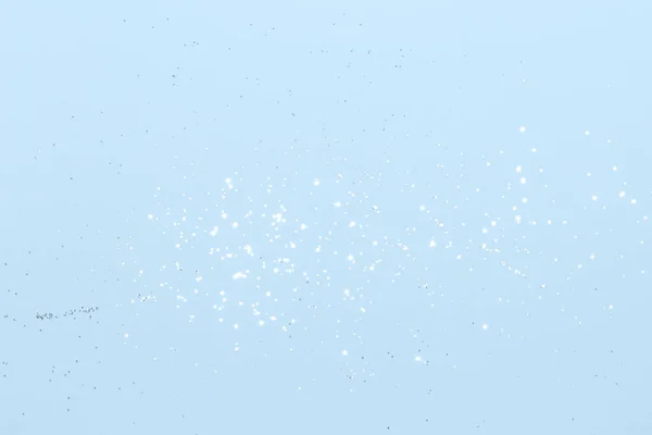 Sparkling silver glitter on blue background. Holiday blurred lights