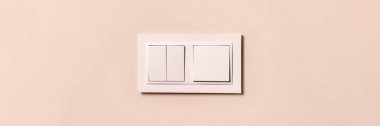 Group of white electrical switches on modern beige wall with copy space banner. Wide panoramic header