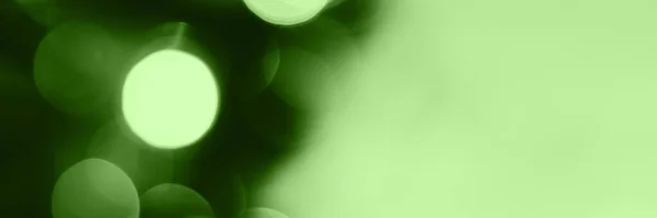 Blurred lights, green background, banner texture. Abstract bokeh with soft light header. Wide screen wallpaper. Panoramic web banner with copy space for design