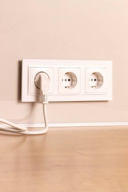 Modern bej duvarına takılı beyaz Avrupa elektrik prizleri grubu