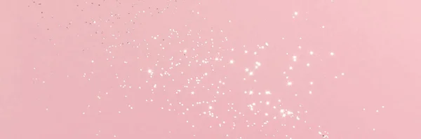 Sparkling silver glitter on pink background banner texture. Abstract holiday blurred lights header. Wide screen wallpaper. Panoramic web banner with copy space for design