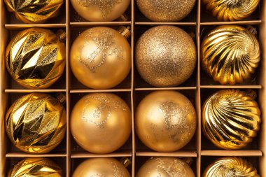 Karton el sanatları kutusunda altın parıltılı Noel ağacı topları. Üst görünüm