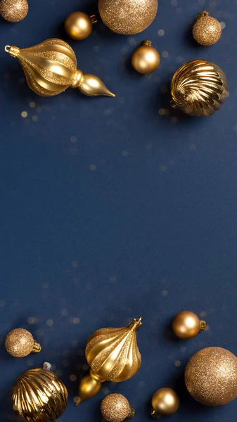 Christmas banner frame with golden glitter balls and toys on blue background with copy space