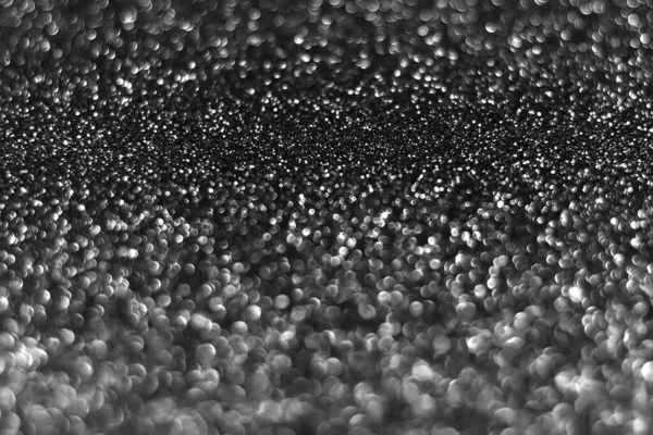 Gray black sparkling glitter bokeh background, christmas abstract defocused texture. Holiday lights. Snowy shiny sparkle stars for celebrate