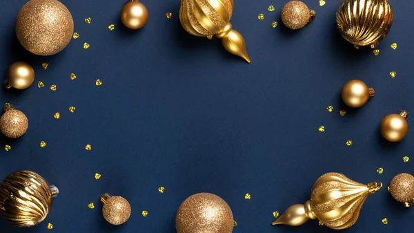 Christmas banner frame with golden glitter balls and confetti on blue background with copy space