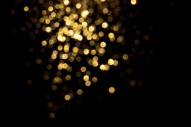 Siyah arka planda altın bulanık bokeh ışıkları. Kutlamak için ışıldayan yıldızlar. Tasarımınız için üstüste