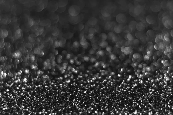 Gray black sparkling glitter bokeh background, christmas abstract defocused texture. Holiday lights. Snowy shiny sparkle stars for celebrate