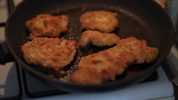 鶏のチョップは クローズアップで揚げられています 黄金の地殻を持つ鶏の鶏はフライパンで輝きます 生のチキンフィレをフライパンで炒める — ストック動画