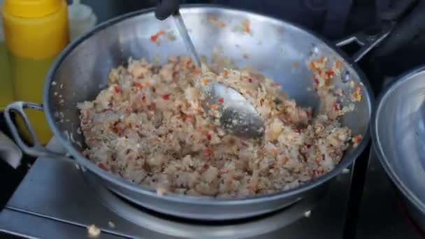 Kok bereidt rijst met groenten en specerijen in een wok. — Stockvideo
