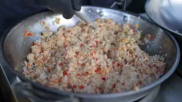 Повар готовит рис с овощами и специями в воке. — стоковое видео
