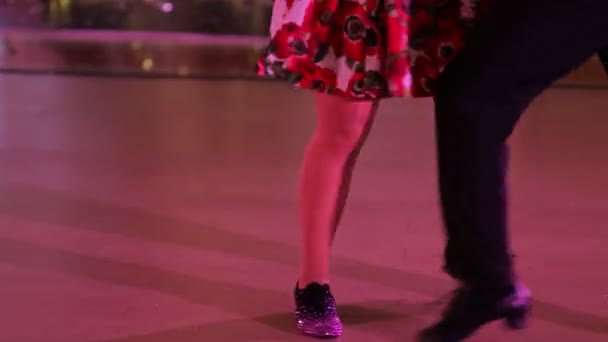 Paar choreografen dansen tango in de hal met parketvloer. — Stockvideo