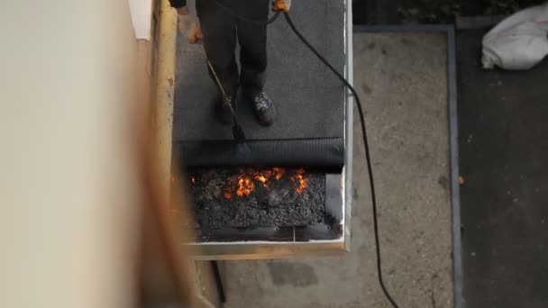 Employé fondre le bitume brûleur à gaz répare le toit de la maison. — Video