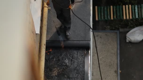 Empregado derreter betume queimador de gás repara o telhado da casa. — Vídeo de Stock