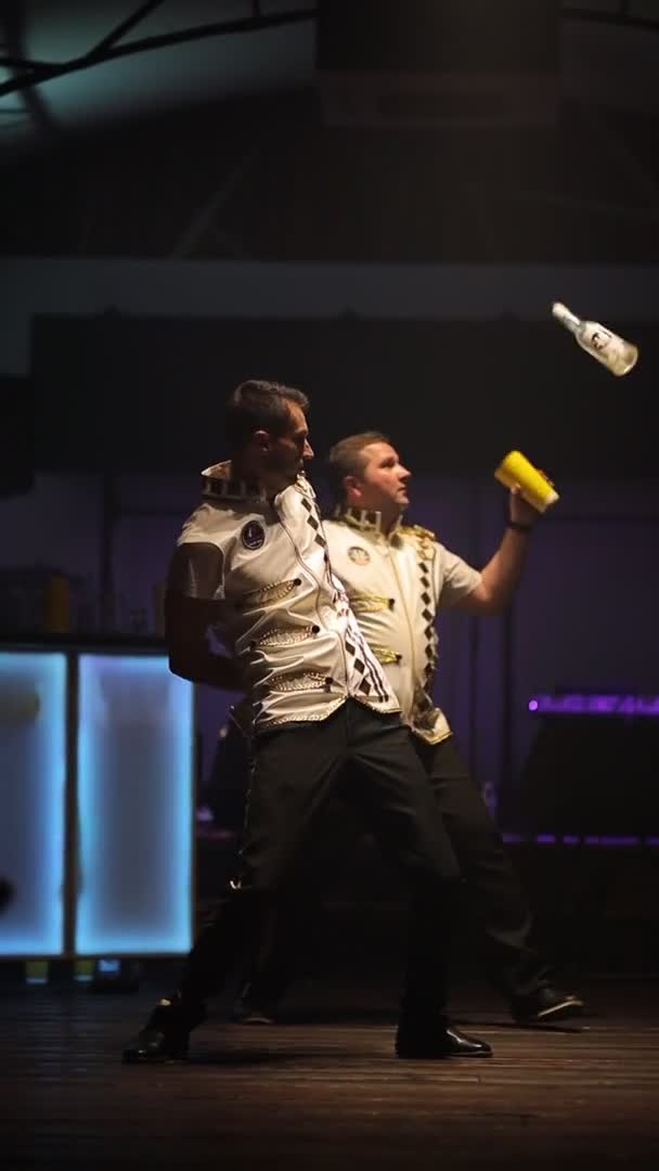 Dos camareros realizan trucos con botellas y cocktails.vertical tiro — Vídeo de stock