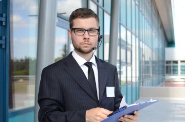 Takım elbiseli genç erkek çağrı merkezi operatörü