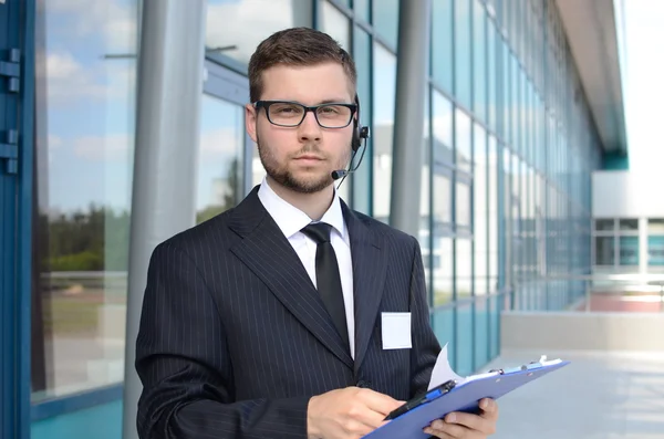 Takım elbiseli genç erkek çağrı merkezi operatörü