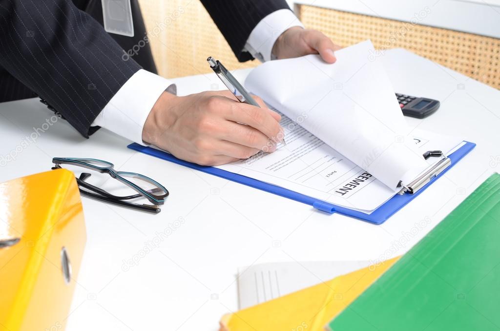 Man in suit signing documents