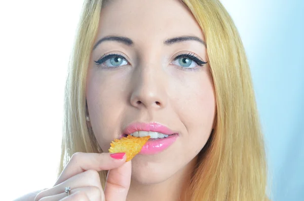 Jovem mulher comendo batatas fritas — Fotografia de Stock