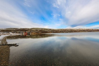 Oppdal belediyesinde bulunan Orkel Gölü manzarası, balık tutmak için ahşap kulübeler ve sadece hafta sonları dinlenme