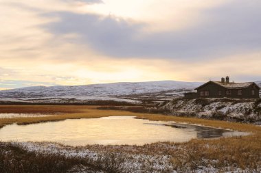 Norveç 'in orta kesimindeki Oppdal belediyesinde bulunan Orkel Gölü yakınlarındaki donmuş bataklığın 10 / 20 / 2018 görüntüsü. Balıkçılık ve hafta sonu turları için tipik bir Norsk kulübesi.