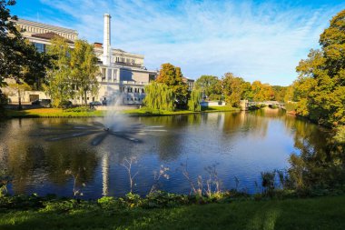 Riga 'da sonbahar, sonbahar renklerinde şehir kanalı manzarası ve suya yansıyan Ulusal Opera binası