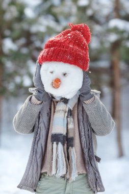 Çocuk bir kardan adam yapıyor. Güneşli bir kış gününde dışarıda oynayan bir kardan adam yapan çocuklar. Noel tatilinde açık hava aile tatili. Erkek ve kız kartopu oynuyorlar..