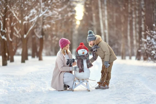 Mutter Und Sohn Bauen Einen Schneemann Familienurlaub Einem Sonnigen Verschneiten Stockfoto