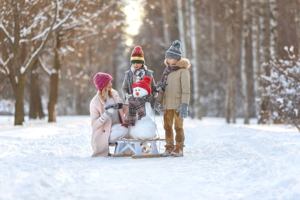 Mutter Und Kinder Basteln Einen Schneemann Familienurlaub Einem Sonnigen Verschneiten lizenzfreie Stockbilder