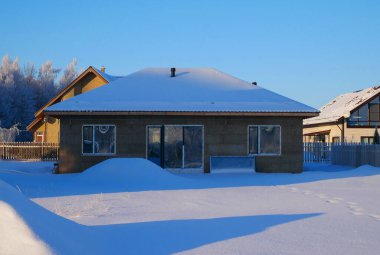 Cottage village near the winter forest. Beautiful houses on the background of a winter landscape.