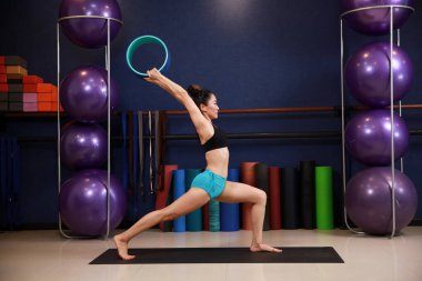 İçeride yoga yapan muhteşem genç bir kadının portresi.