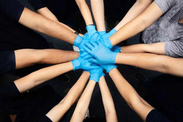 Close up top view of Volunteer  people putting their hands together. Stack of hands showing unity and teamwork to fighting corona virus (Covid-19)