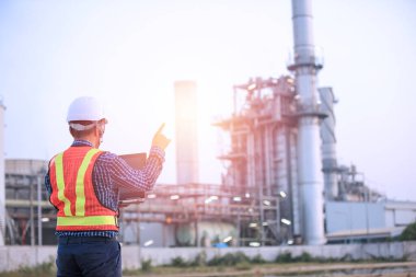 engineer and engineering concept. Man in helmet and protective suit near plant