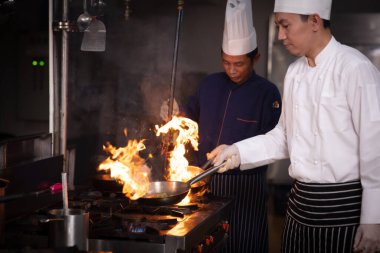 Chelf ve yardımcıları mutfakta yemek pişiriyordu, uzman aşçı mutfakta ateş tavası pişiriyordu.