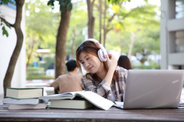 Asya 'lı genç stent kulaklık takıyor ve öğreniyor. 