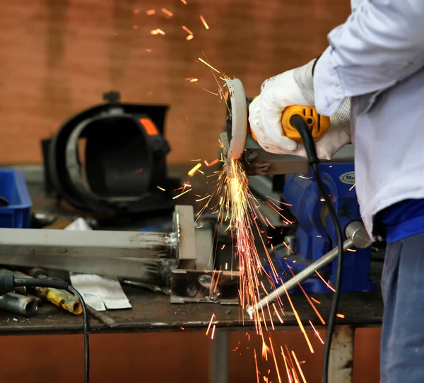Technician grinding metal, metal work in maintenance shop