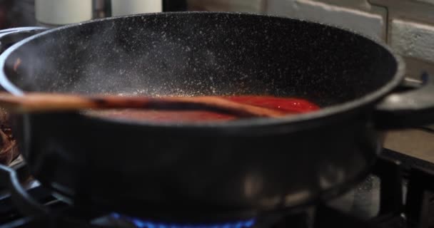 Şef su döker ve domates ezmesini kaynar yağla karıştırır. — Stok video
