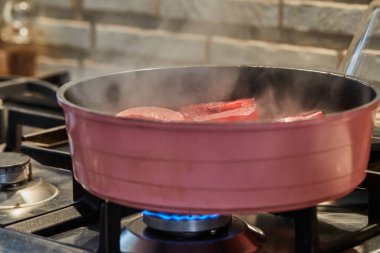 Kesilmiş armutlar kırmızı şerbetle kaynatılır ve gaz sobasında şarap olur..