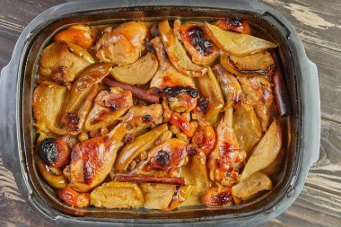 Ballı tavuk bacağı, kuru üzüm, karamelli elma ve fırında pişirilmiş armut. Düz yatıyordu. Kapat.