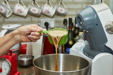 Şef kepçeden köpüklü birayı kaseye döker..