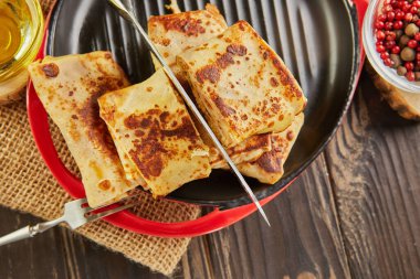 Etli gözleme, bıçakla kesilmiş siyah ahşap kaplama.