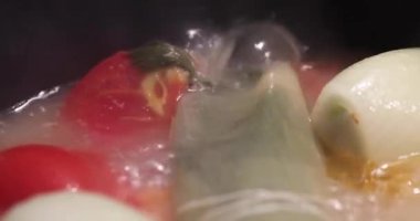 Tencerede buharlı sebzeler kaynıyor.