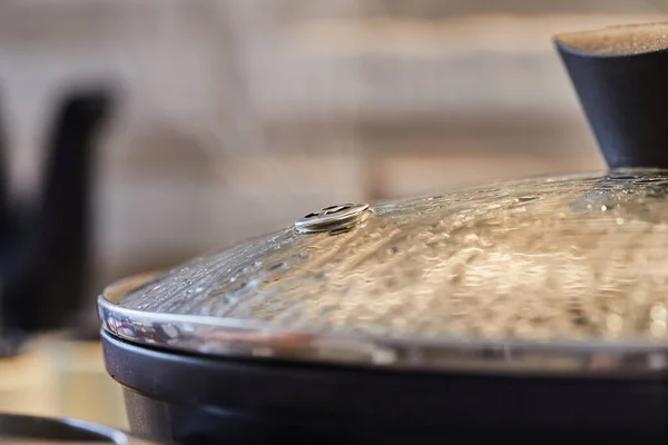 Tapa de la sartén con gotas y primer plano de vapor, en la cocina — Foto de Stock