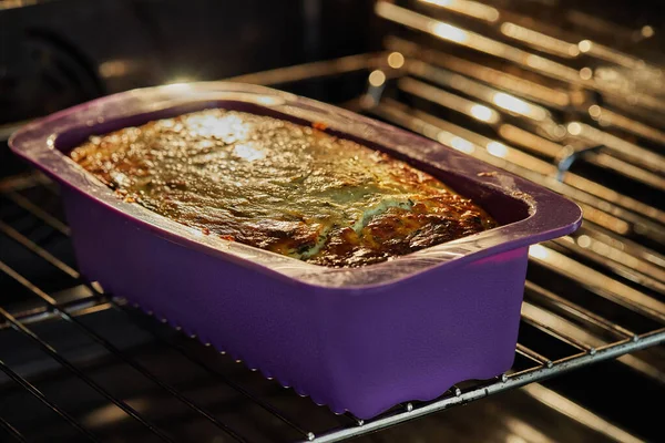 Potatoes and cheese gratin in silicone mold in an electric oven after baking — Foto Stock