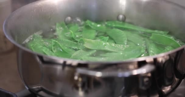 Grüne Erbsen werden im Topf auf dem Gasherd gekocht — Stockvideo