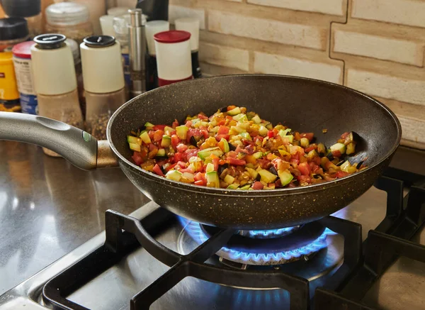 Prato com berinjela, abobrinha e pimentão é frito na panela no fogão a gás — Fotografia de Stock