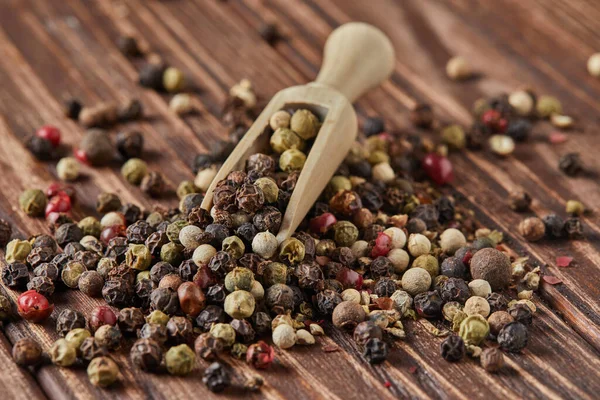 Mix di peperoni multicolore con spatola in legno sparsa su fondo di legno vintage — Foto Stock
