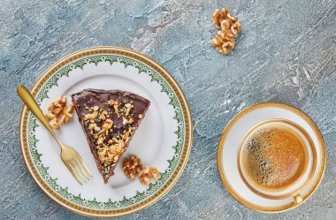 Armutlu çikolatalı kek ve bir fincan kahveyle tabakta ceviz. Düz yatıyordu