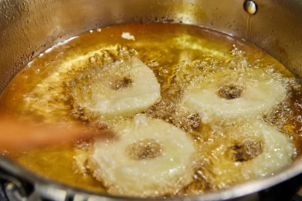 Cooking apple pancake. Chef flips the Apple Donut in the simmering oil — Stock fotografie