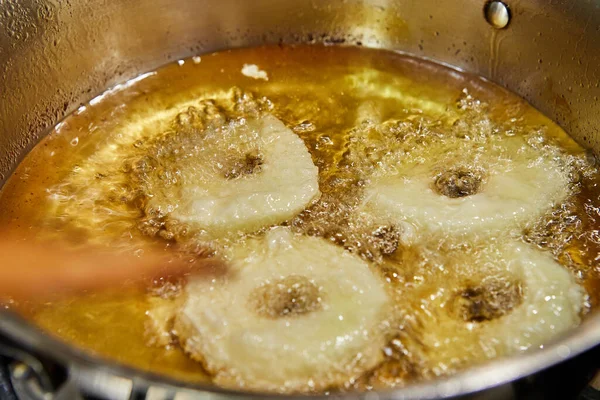 Koka äppelpannkaka. Chef vänder Apple Donut i den vibrerande oljan — Stockfoto