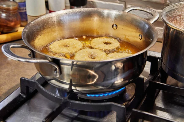 Cooking apple pancake. Apple donut in boiling oil — стоковое фото